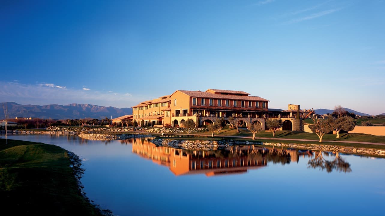Hotel Peralada reflected in the resort pond beside the golf course
