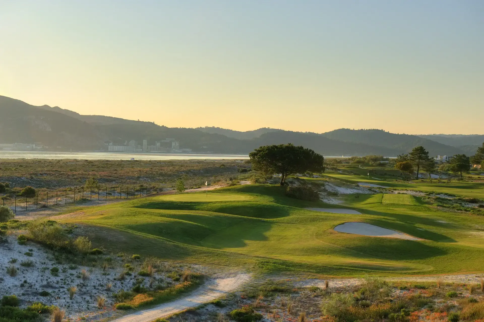Troia Golf coastal greens and Arrabida hills at sunset